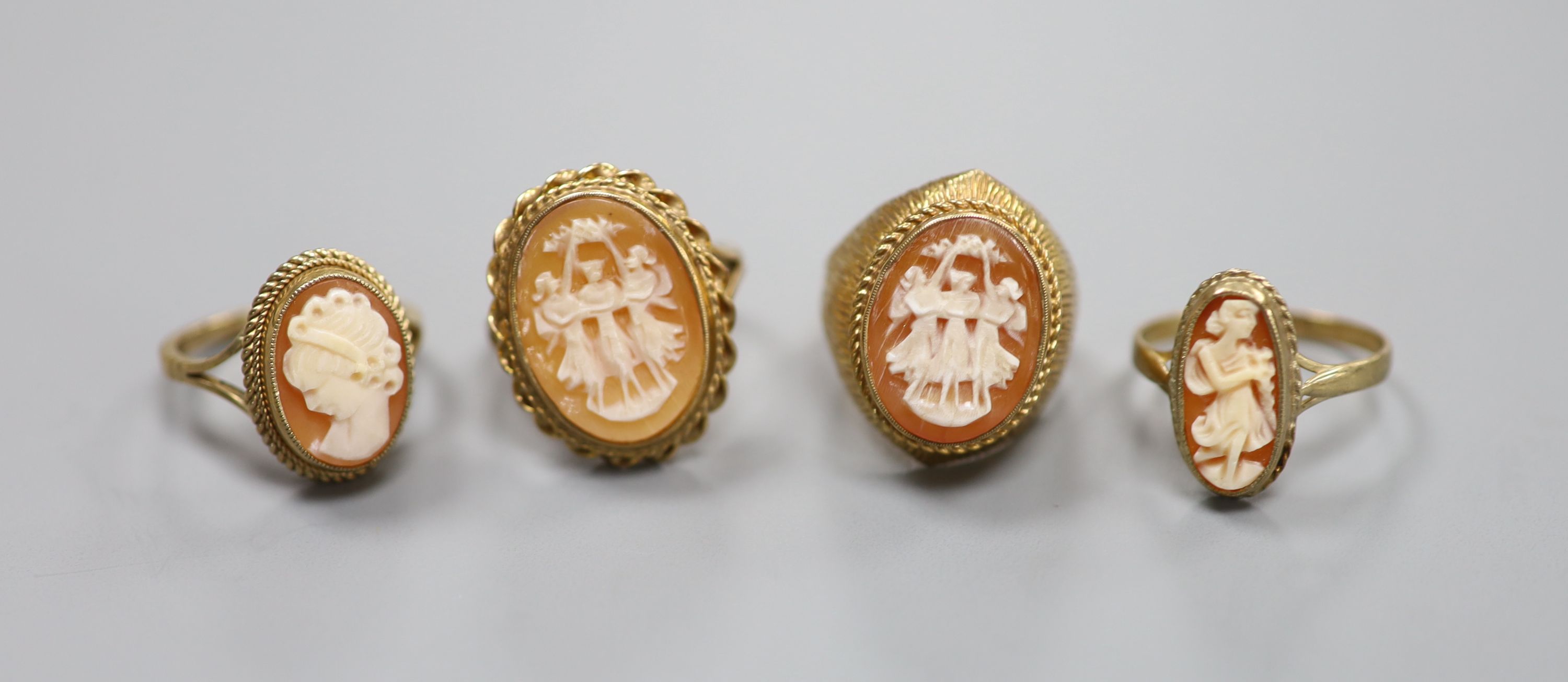 Four assorted modern 9ct and cameo shell dress rings including one carved with The Three Graces